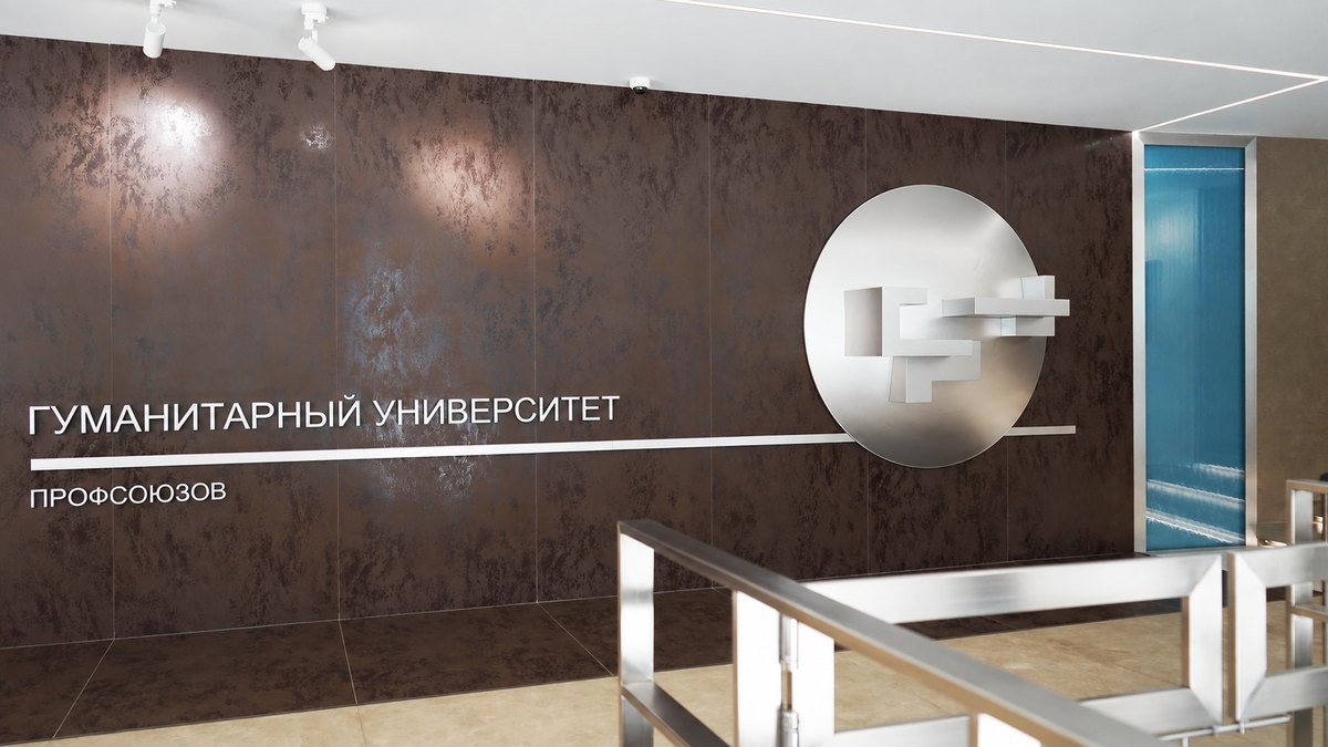 Узкая водная панель справа от круглой эмблемы и надписей на стене университета