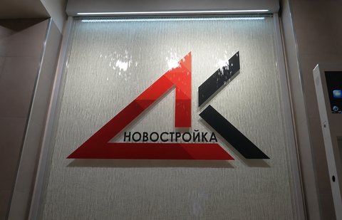 Верхняя часть стеклянного водопада со знаком «НОВОСТРОЙКА» и световой полосой